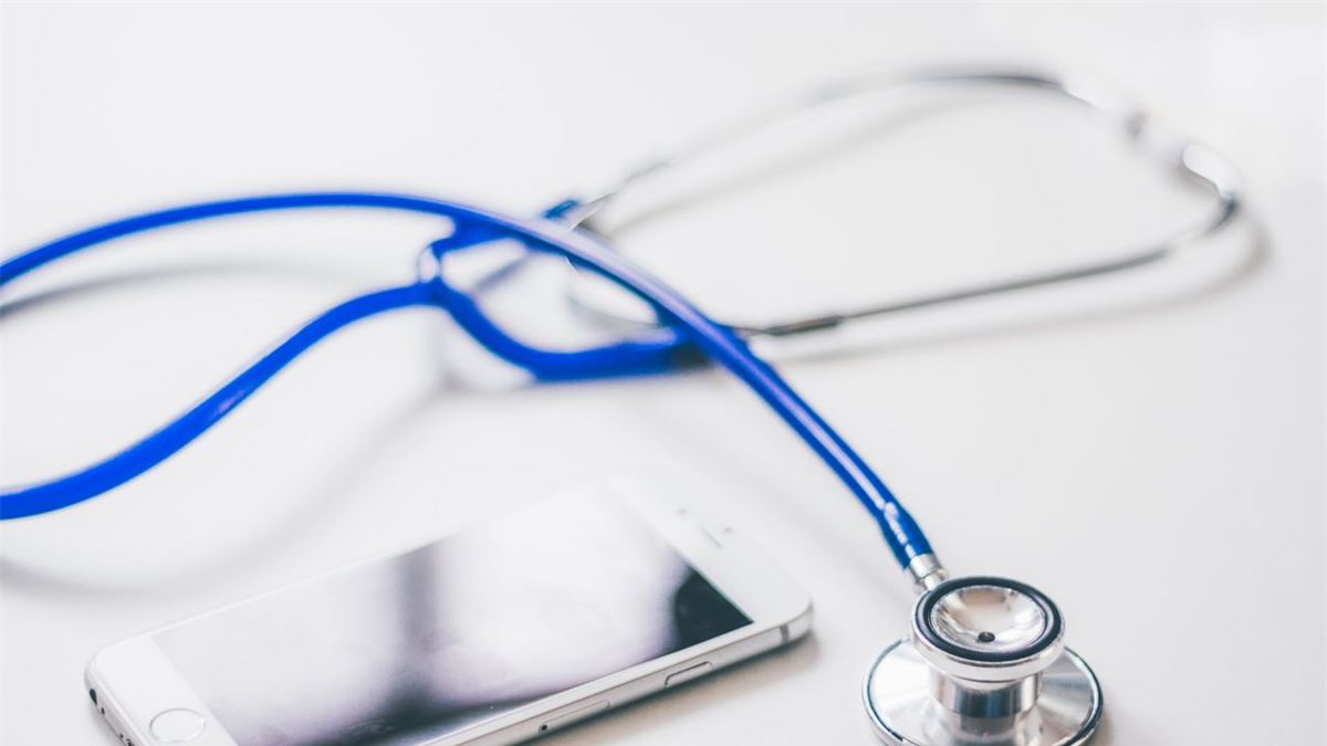 Smartphone et stéthoscope sur une surface blanche