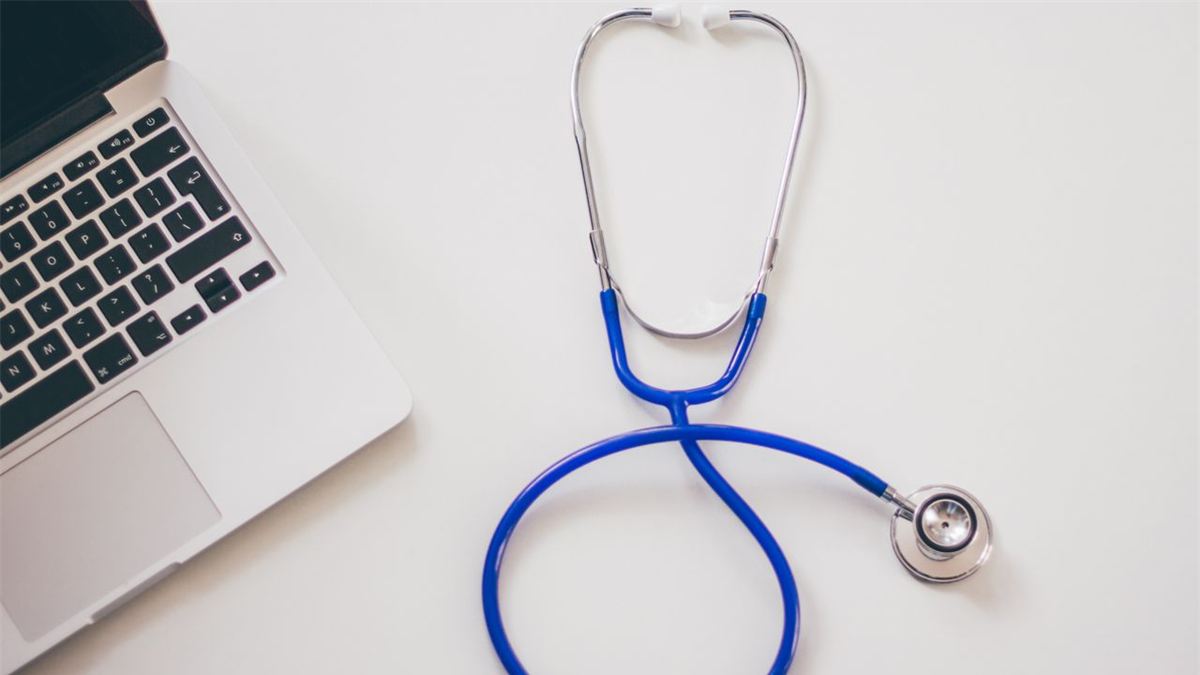 Stéthoscope et ordinateur portable sur un bureau blanc