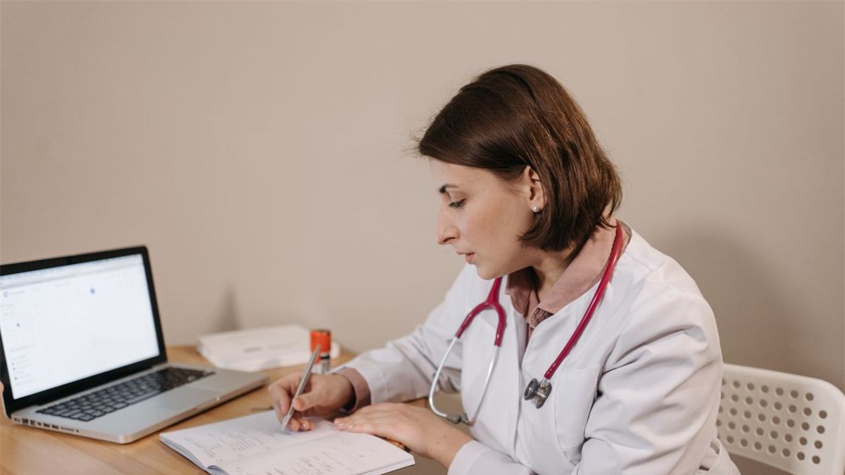 Médecin écrivant à son bureau