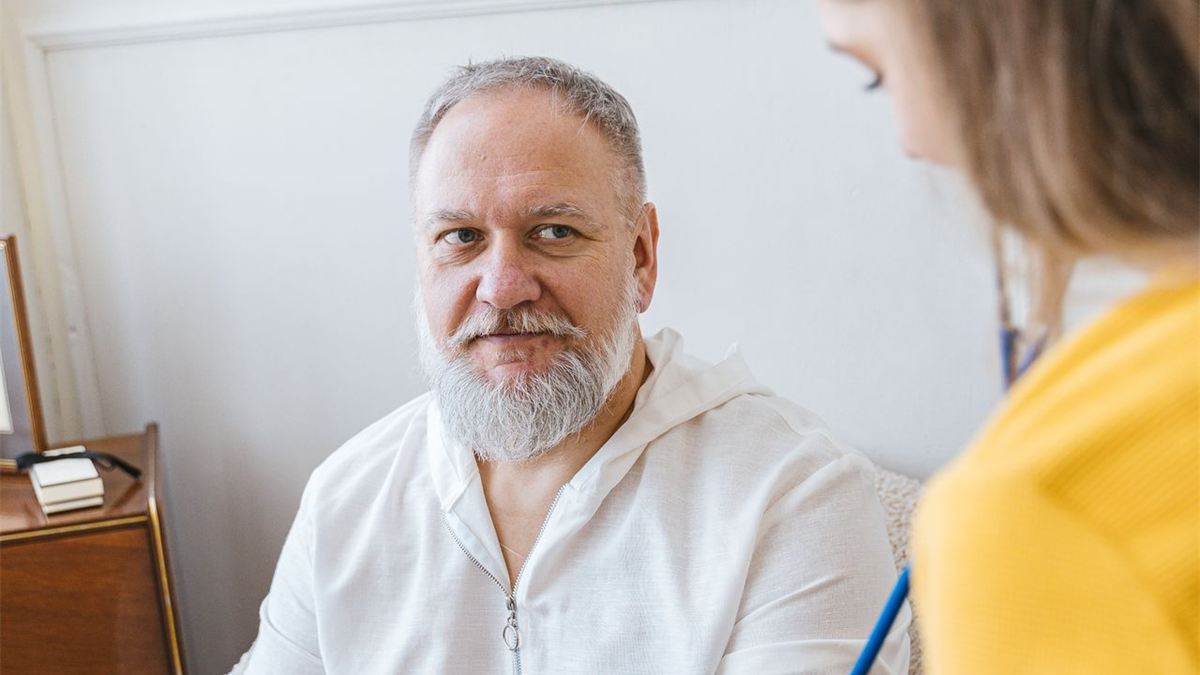 Soignant prenant la tension d'un patient âgé à domicile
