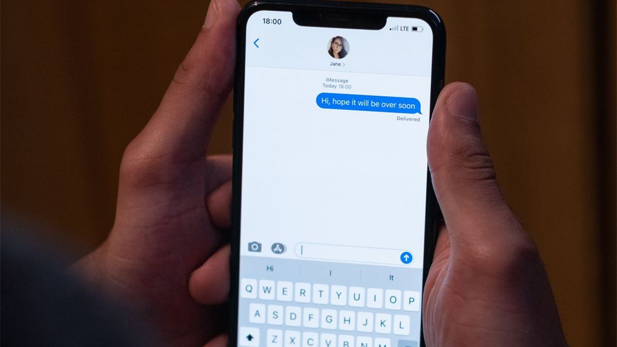 Mains tenant un smartphone avec une conversation