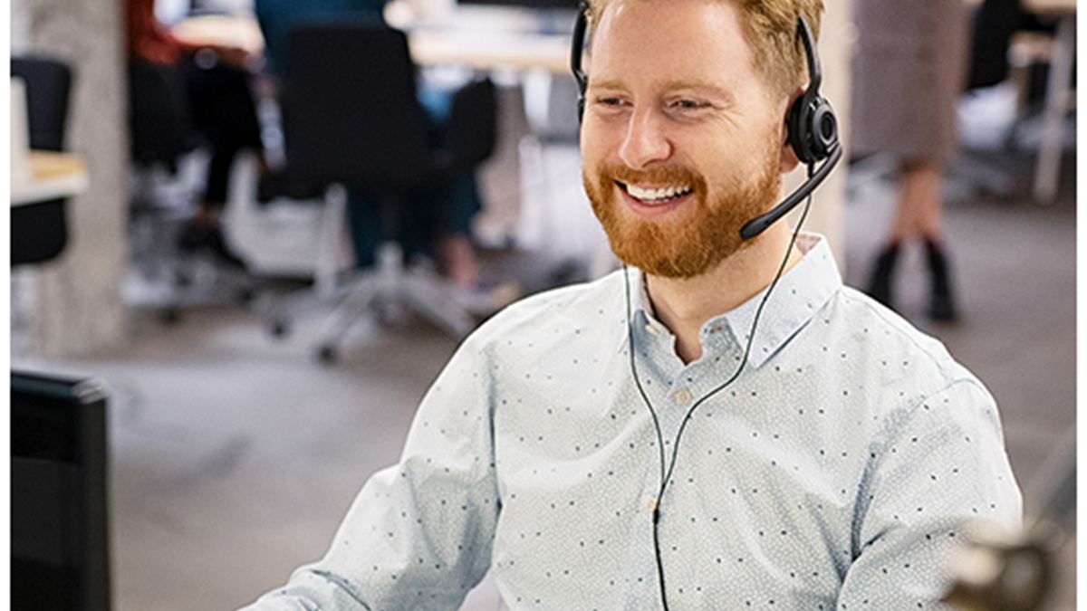 Secrétaire avec casque souriante dans un open space