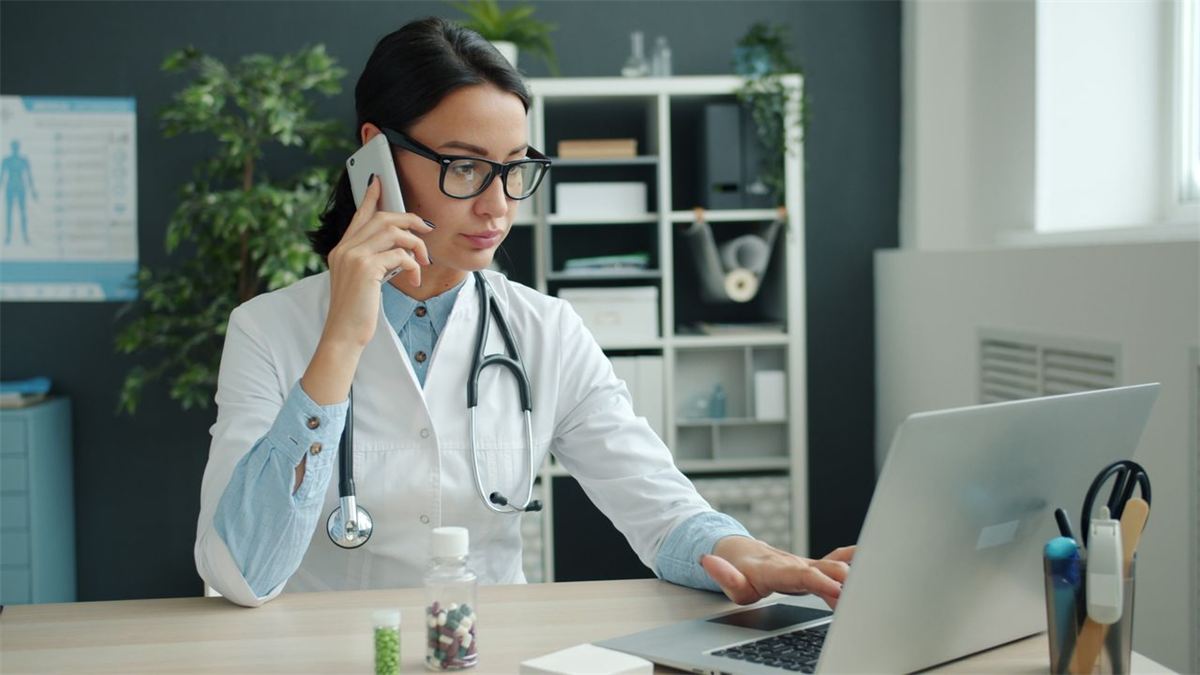 Médecin au téléphone devant son ordinateur